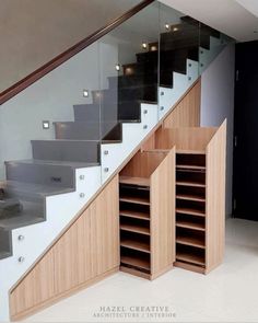 an open bookcase under the stairs in a home