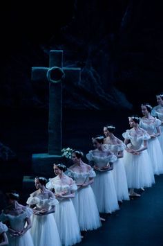 several ballerinas are lined up in white dresses