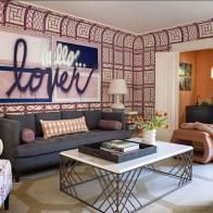 a living room filled with furniture and a painting on the wall above it's coffee table