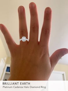 a woman's hand with a diamond ring on it and the words brilliant earth written below