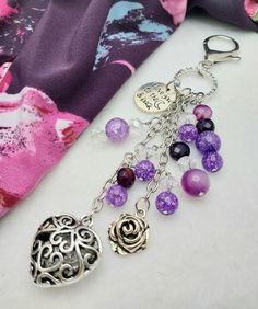 a close up of a key chain with charms on it and a scarf in the background