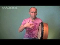 a man sitting on top of a wooden drum