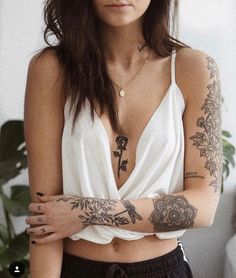 a woman with tattoos on her arms and chest