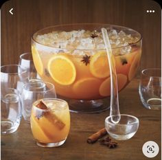 an image of a bowl of food with oranges and cinnamon on the side next to glasses