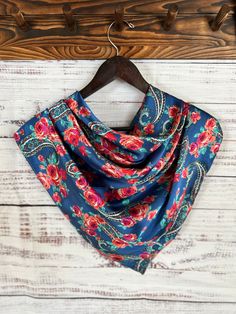 This wild rag has a pretty floral pattern on a blue background with a pop of western from the paisley print scattered throughout. Made of lightweight silky satin fabric and sewn with a rolled edge hem for a neat finished look.  These satin wild rags are so versatile, with many fun and practical ways to style them. Perfect for keeping the working cowboys and cowgirls warm on those cold days out in the weather or use them as a fashion accessory to add a western flare to any outfit. These wild rags can be styled as a neckerchief, bandana, hair tie, head band, head wrap, belt, wild rag top and so much more! Find N3 wildrags across your social media platforms for tips on how to style them.  ** all wild rags in my shop are handmade by me in the USA Summer Bandana Print Patterned Scarves, Blue Silk Scarf With Paisley Print, Bohemian Silk Shawl With Floral Print, Bohemian Silk Floral Print Shawl, Blue Bohemian Scarf With Paisley Print, Blue Bohemian Scarves With Floral Print, Blue Bohemian Headscarf For Summer, Blue Paisley Print Bohemian Scarf, Blue Bohemian Paisley Print Scarves