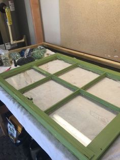 an old window is sitting on top of a table in the process of being painted