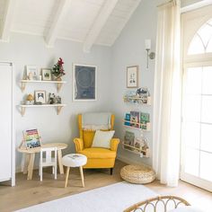 a yellow chair sitting in a living room next to a white rug on top of a hard wood floor