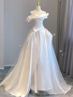 Taking inspiration from old Hollywood glamour, this beautiful A-line wedding dress is a true showstopper. The off-the-shoulder neckline and delicate pleats add a touch of elegance and sophistication to the dress, while the soft tulle fabric creates a dreamy and ethereal feel. White Off The Shoulder Wedding Dress, White Cotillion Dresses, White Ballgown Dress, Wedding Venues Church, Off The Shoulder Wedding Dress, Winter Wedding Venues, Tulle Wedding Dresses, Shoulder Wedding Dress, Tulle Sleeves