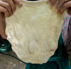 a person holding a dough ball in their hands