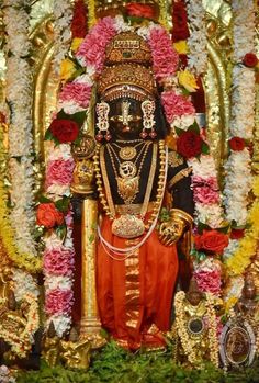 the statue is surrounded by flowers and garlands