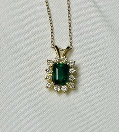 "This listing is for a ladies 14k yellow gold pendant set with a single emerald cut emerald and 12 round brilliant cut diamonds. The emerald is set in the center with the diamonds set all the way around. The emerald itself is set with prongs in yellow gold while the diamonds are set with 2 prongs in yellow gold. The pendant has a high polish finish. This necklace includes an updated appraisal from an independent appraiser. Emerald info: Nature: Natural Shape: Emerald cut faceted Estimated weight 14k Gold Emerald Cut Emerald Necklace, Classic Emerald-cut Diamond Emerald Necklace, Classic Emerald Cut Diamond Necklace, Elegant Stamped 14k Rectangular Pendant Jewelry, Fine Jewelry Emerald Cut Emerald Necklace For Formal Events, Gold Emerald Cut Necklace For May Birthstone, Emerald Cut Emerald Necklace With Diamond Accents Gift, Gold Emerald-cut Necklace With Diamond Details, Classic Emerald Cut Emerald Necklace For May Birthstone