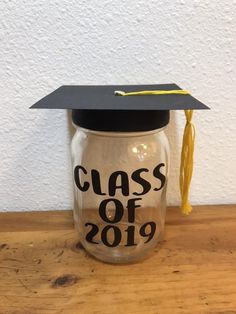 a graduation cap on top of a glass jar with the words class of 2019 printed on it