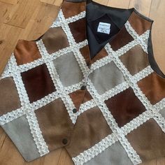 the vest is made up of different colors and patterns, including brown, white, and black squares