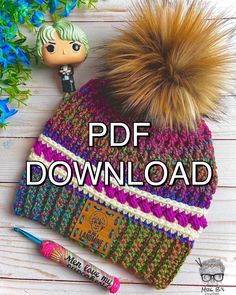 a knitted hat with a pom - pom sitting on top of it