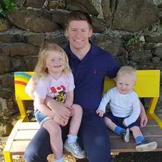 a man and two children sitting on a bench