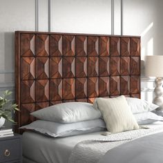 a bed with white pillows and wooden headboard