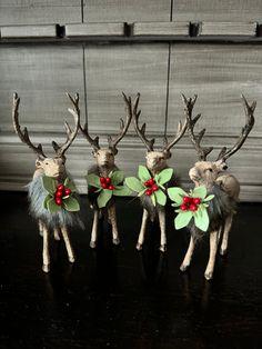 four reindeer figurines with green and red bows on their antlers, standing next to each other