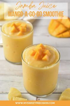 two glasses filled with mango smoothie on top of a table