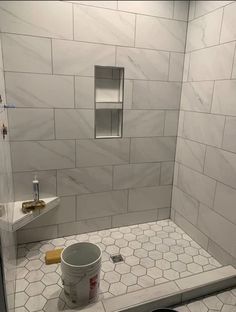 a white tiled bathroom with a tub and toilet