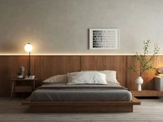 a modern bedroom with wood paneling and white bedding, two nightstands on either side