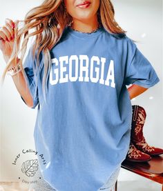 Georgia Shirt, Comfort Colors®, Georgia Fan Crewneck Sweatshirt, vintage Georgia Sweatshirt, Georgia Gift, College Student gift, Boho Tshirt Hi, thank you so much for shopping with us! ❤️ ◦ ◦ ◦ ◦ ◦ size and material ◦ ◦ ◦ ◦ ◦ ◦ Comfort Colors® Original Garment-Dyed T-shirt ◦ Unisex Adult T-Shirt ◦ Soft and comfy ◦ Garment-dyed and soft-washed for a comfortable vintage look and feel ◦ Relaxed fit ◦ 100% ring-spun cotton ◦ The way that we print our sweatshirts is Direct-to-Garment printing, meaning that the ink is printed INTO the shirt. This provides an extremely durable and professional look (not vinyl).  ❤️❤️ IF YOU WANT AN OVERSIZED LOOK PLEASE CHOOSE A SHIRT THAT IS 2 SIZES LARGER THAN YOUR USUAL SIZE  ◦ ◦ ◦ ◦ ◦ care instructions ◦ ◦ ◦ ◦ ◦ ◦ Machine wash: cold (max 30C or 90F) ◦ Do not College Crew Neck T-shirt With Letter Print, Vintage College T-shirt With Lettering, Retro Crew Neck Pre-shrunk Top, Vintage Relaxed Fit T-shirt For College, Crew Neck T-shirt With Lettering For College, School Spirit Crew Neck T-shirt With Letter Print, School Spirit T-shirt With Letter Print And Crew Neck, School Spirit T-shirt With Letter Print, Vintage T-shirt With Lettering For College