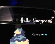 a car mirror with the words hello gorgeous on it and a tie hanging from it's side