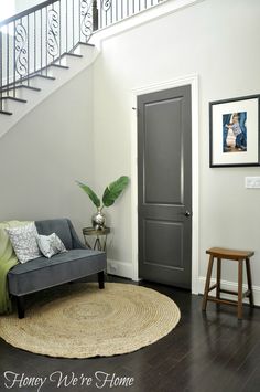 a living room with a gray door and stairs