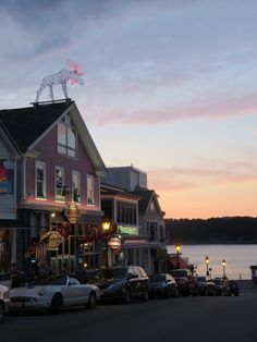 cars are parked in front of shops along the water