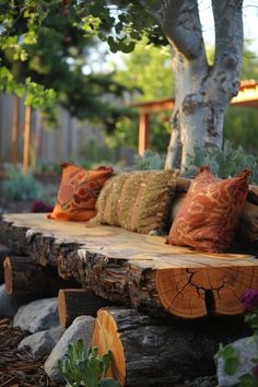 a bench made out of logs with pillows on it