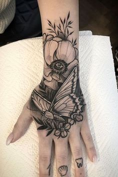 a woman's hand with a tattoo on it and a flower in the middle