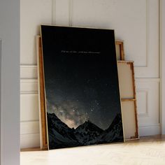 a framed photograph sitting on top of a hard wood floor next to a white wall