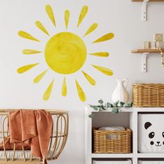 a yellow sun painted on the wall in a child's room with baskets and toys