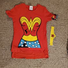 a t - shirt with wonder woman on it next to a pair of scissors and glue