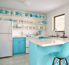 a kitchen with blue cabinets and white counter tops, two bar stools in front of the island