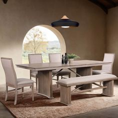 a dining room table with chairs and a bench in front of an arched window that looks out onto the countryside