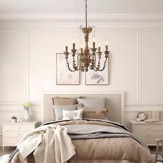 a bedroom with a chandelier hanging from the ceiling and two pictures on the wall