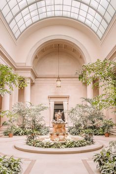 the inside of a building with many plants and trees in it's center area