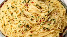 a bowl filled with pasta and topped with parsley