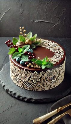 a chocolate cake decorated with berries and greenery