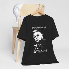 Michael Myers "My Personal Stalker" V-Neck T-Shirt, Funny Michael T-shirt, Halloween Gift, Horror Character Hoodie, Funny Michael Myers Fan Shirt. Get this shirt and let everyone know you love Halloween and scary movies. This classic unisex jersey short sleeve tee fits like a well-loved favorite. Soft cotton and quality print make users fall in love with it over and over again. These t-shirts have-ribbed knit collars to bolster shaping. The shoulders are tapered for a better fit over time. Dual side seams hold the garment's shape for longer. .: Made with 100% Airlume combed and ring-spun cotton, a lightweight fabric (4.2 oz/yd² (142 g/m that is easy to layer, breathable. Perfect for active and leisure wear.  .: The retail fit that is perfect for casual and semi-formal settings. The crew ne Funny Michael Myers, Love Halloween, Horror Characters, Fan Shirts, Michael Myers, Scary Movies, Halloween Gift, Leisure Wear, Jersey Shorts