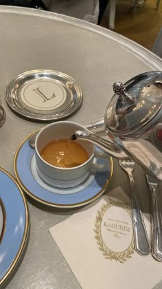 a table topped with plates and bowls filled with soup next to utensils on top of a table