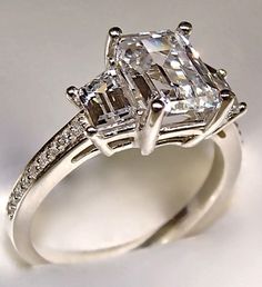 an engagement ring with two assorted princess cut diamonds