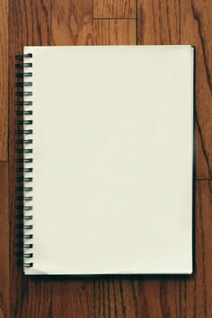 an open notebook sitting on top of a wooden floor