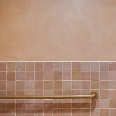 a bathroom with pink tile and gold fixtures