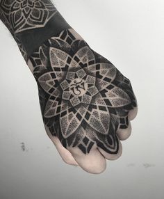 a person's hand with a tattoo on it and an om sign in the middle