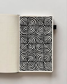 an open book with black and white designs on it