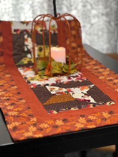 a table with a candle and quilt on it