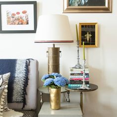 a living room with a couch, table and pictures on the wall above it that is decorated with blue hydrangeas