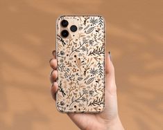 a person holding up an iphone case with floral designs on the front and back cover