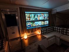 a living room with couches and a flat screen tv on the wall in front of it